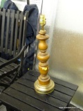 WOODEN TABLE LAMP; HAS A BRASS BASE AND MEASURES 24 IN TALL