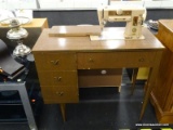 VINTAGE SINGER SEWING MACHINE IN A MAHOGANY CABINET WITH 3 DRAWERS ON THE LEFT HAND SIDE. IS IN GOOD