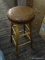 (R5) BARSTOOL; HAS A BROWN LEATHER SEAT AND OAK LEGS. MEASURES 14 IN X 14 IN X 29 IN