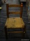 (R5) CHILDS CHAIR; SOLID OAK WOVEN SEAT CHILDS CHAIR. MEASURES 14 IN X 12 IN X 22 IN
