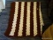 (R1) BROWN AND WHITE STRIPED AFGHAN THROW; MEASURES ABOUT 56 IN X 44 IN.