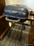 CHARCOAL GRILL; DARK BLUE IN COLOR, WITH HANDLES ON SIDE AND A FOLDING X-SHAPED BASE THAT HAS 2