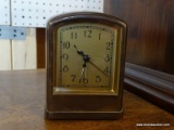 (R1) POTTERY BARN ALARM CLOCK; BROWN METAL CASE WITH BRASS COLORED FACE AMD A SLIGHTLY ROUNDED TOP.