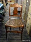 (R5) CANE BOTTOM SIDE CHAIR; HAS A FIDDLE BACK, CANE BOTTOM SEAT, AND SABER LEGS. MEASURES 16 IN X