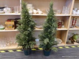 (R1) PAIR OF POTTED ARTIFICIAL EVERGREEN TREES; EACH MEASURES ABOUT 48 IN TALL (4 FT). PLANTED POT