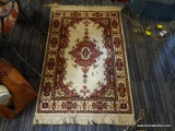 (R2) SMALL FRINGED AREA RUG; BEIGE IN COLOR WITH PATTERNED BORDER AND CENTER IN SHADES OF MAROON AND