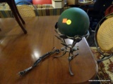 (R2) GREEN GAZING BALL LAMP ON IRON BASE; DARK GREEN LIGHTED SPHERE SITTING IN A FLORAL PATTERNED