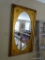 (UP) OVAL SHAPED MIRROR IN LARGE RECTANGULAR GOLDEN COLORED FRAME; MEASURES 24 IN WIDE AND 42 IN