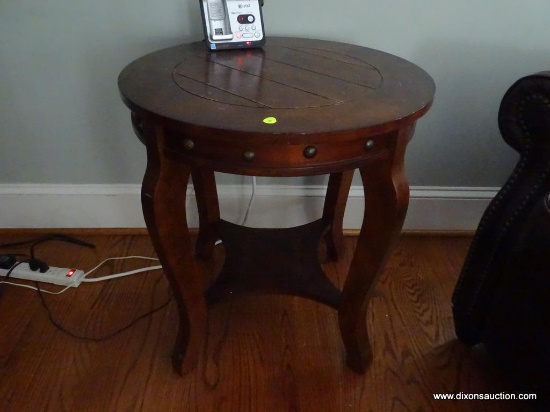 (LR) ROUND WOODEN END TABLE; PANELED DETAIL ON TOP SURFACE WITH ROUND RIVETED TRIM ON APRON BENEATH.