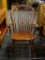 VINTAGE BOW BACK ROCKING CHAIR; THIS ROCKING CHAIR HAS A CARVED DETAILED TOP, BOW BACK, ROLLED ARMS,
