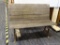 VINTAGE WOOD AND METAL BENCH; PLANK STYLE WOODEN BENCH SITTING ON A CAST IRON BASE WITH TWO FEET.