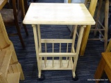 ROLLING END TABLE; MADE OF MAPLE AND HAS A LOWER MAGAZINE RACK. MEASURES 14 IN X 19 IN X 29 IN