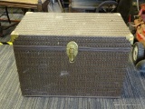 TRUNK; HAS A BROWN WOVEN STYLE EXTERIOR AND BRASS HARDWARE. MEASURES 28 IN X 16 IN X 20 IN. IS IN