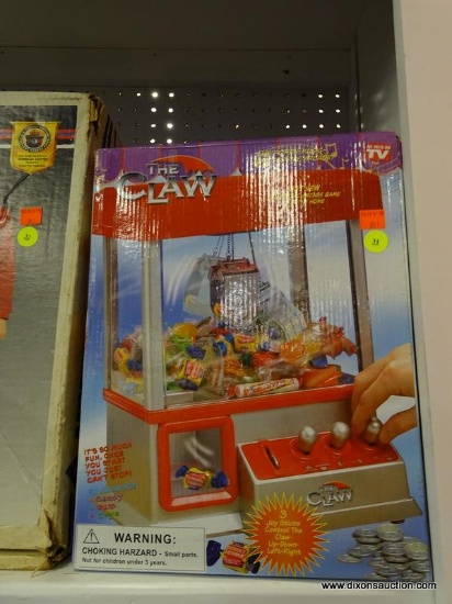 THE CLAW PORTABLE ARCADE GAME; IN ORIGINAL BOX, 3 JOYSTICKS CONTROL MOVEMENT, FILL WITH CANDY OR