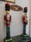 PAIR OF LARGE DECORATIVE NUTCRACKERS; RED, GREEN, BLACK, AND GOLD IN COLOR. WORKING LEVER ON ONE,