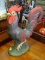 ROOSTER FIGURINE; IS GREEN AND RED IN COLOR AND MEASURES 13 IN X 15 IN