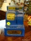 VINTAGE COIN BANK; BLUE AND YELLOW IN COLOR AND ACCEPTS NICKELS, DIMES, AND QUARTERS. CURRENTLY HAS