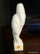 CERAMIC DECOR PIECE; THIS WHITE STATUE SHOWS TWO FACES THAT LEAD DOWN TO LONG INTERTWINED NECKS