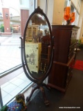 MAHOGANY OVAL-SHAPED CHEVAL; CVLA WOOD FRAMED MIRROR WITH CARVED VICTORIAN FLORAL DESIGN AT APEX,