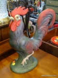 ROOSTER FIGURINE; IS GREEN AND RED IN COLOR AND MEASURES 13 IN X 15 IN