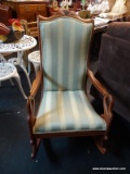 ROCKING CHAIR WITH GOOSENECK ARMS; HAS GRAPE CARVED CREST AND STRIPED UPHOLSTERY. IS IN EXCELLENT