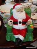 LARGE SANTA COOKIE JAR; SANTA CLAUS IS RELAXING IN A GREEN ARMCHAIR WITH COFFEE IN HAND, REVIEWING
