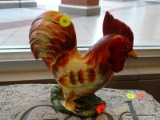 PAINTED CAST IRON ROOSTER DOOR STOP; BRIGHTLY COLORED IN HUES OF YELLOW, ORANGE, AND REDS WITH A