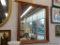 FRAMED WALL MIRROR; LARGE WALL MIRROR FRAMED IN A THICK WOODEN FRAME. MEASURES 35 IN X 41 IN.