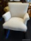 UPHOLSTERED ARM CHAIR; 1 OF A PAIR OF CREAM UPHOLSTERED ARM CHAIRS WITH MAHOGANY LEGS. VERY CLEAN
