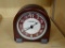 FOSSIL DESK CLOCK; CHERRY COLORED WOOD GRAIN DESK CLOCK WITH CREAM AND TAN STRIPED BACKGROUND.