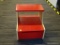 RED AND MAPLE STEP STOOL; HAS LIFT LID ON THE LOWER STEP THAT OPENS TO REVEAL STORAGE AND MEASURES