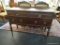 ANTIQUE FEDERAL STYLE SIDEBOARD; HAS 2 DRAWERS WITH OVAL BESSELS AND REEDED SHERATON STYLE LEGS. HAS