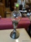 CANDLE STICK HOLDER; METAL CANDLESTICK HOLDER WITH GLASS SHADE. MEASURES 16 IN TALL