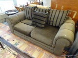 GRAMERCY HILL LOVESEAT; IS BROWN IN COLOR WITH ROLLED ARMS AND BROWN AND BLACK STRIPED PILLOWS.