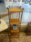WICKER AND WROUGHT IRON SHELF; FOUR TIERED BROWN WICKER SHELF WITH A BLACK WROUGHT IRON FRAME THAT