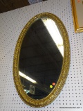 OVAL WALL MIRROR; OVAL WALL MIRROR FRAMED IN A GOLD FRAME WITH A LEAF AND BEADED DESIGN. MEASURES