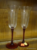 PAIR OF CHAMPAGNE FLUTES; RED STEMMED CHAMPAGNE FLUTES. MEASURE 8.5 IN.