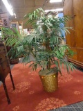 ARTIFICIAL FERN PLANT; SITS IN A WOVEN BASKET. LEAVES SPAN APPROXIMATELY 32 IN, AND THE PLANT STANDS