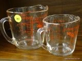 ANCHOR HOCKING FIRE-KING MEASURING CUPS; PAIR OF GLASS MEASURING CUPS. LARGE CUP HOLDS UP TO 16 OZ.