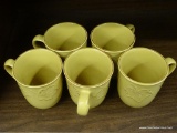 SET OF COFFEE MUGS; SET OF 5 MUSTARD COLORED COFFEE MUGS WITH RAISED LEAF PATTERN. THE RIM, HANDLE,