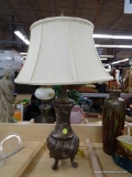 BRUSHED TABLE LAMP; CREAM COLORED WIDE BELL SHAPED LAMP SHADE SITTING ATOP A BRUSHED TWO-TONED URN