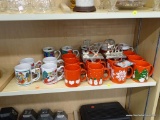 3/4 SHELF LOT; INCLUDES VARIOUS COFFEE MUGS, JOY AND PEACE SHELF HANGERS, ETC.