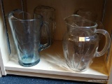 LOT OF PITCHERS; THIS 4 PIECE LOT INCLUDES: 3 CLEAR GLASS PITCHERS, AND BLUE GLASS PITCHER. LARGEST
