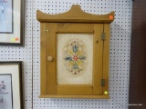 MEDICINE CABINET; PINE WALL HANGING CABINET WITH LATCHING DOOR AND INTERIOR SHELVES. HAS A FLORAL