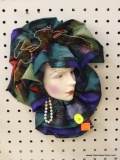 HAND PAINTED WALL HANGING; THIS PIECE IS HAND PAINTED WOMAN'S FACE WITH FAUX PEARLS HANGING DOWN AND