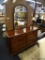CRESENT MANUFACTURING CO. MIRRORED DRESSER; 8 DRAWER CHERRY DRESSER WITH BEVELED MIRROR BACK AND