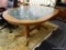 TILE TOP DINING TABLE; FEATURES A WOOD GRAIN OVAL TOP WITH A GREEN MARBLED AND FLORAL TILE INLAY.