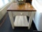 RUSTIC SIDE TABLE; FEATURES A BROWN PANELED TOP WITH A CREAM COLORED BASE THAT INCLUDES A SINGLE