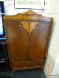 VINTAGE ARMOIRE; FEATURES A SCROLL CARVED CROWN AND TWO SCROLL CARVED DOORS THAT OPEN TO REVEAL