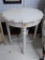 ROUND END TABLE; HAS A PIE CRUST TOP WITH REEDED COLUMN LEGS AND CROSS STRETCHER BASE. MADE BY